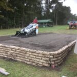Bobcat grading and leveling driveway on RV pad