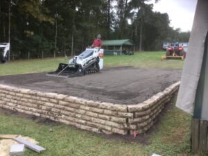 Bobcat grading and leveling driveway on RV pad